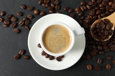 Téléchargez les photos : Coupe de café aromatique et haricots sur table noire, plat laïc - en image libre de droit