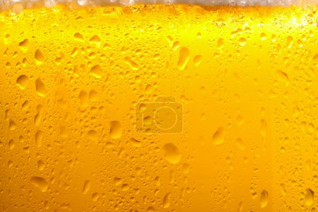 Photo for Glass of tasty cold beer with foam and condensation drops as background, closeup - Royalty Free Image
