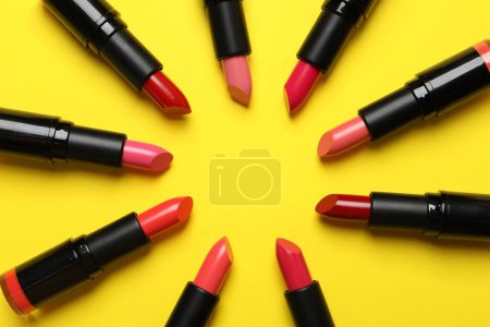 Frame of bright lipsticks on yellow background, flat lay. Space for text Poster 620594636