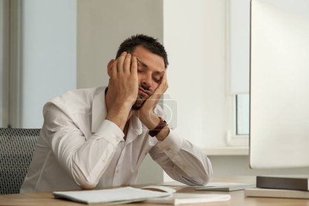 Téléchargez les photos : Homme endormi somnolant sur le lieu de travail dans le bureau - en image libre de droit