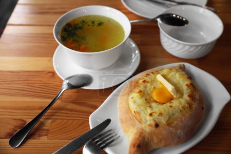 Téléchargez les photos : Délicieux Adjarian khachapuri frais avec fromage et oeuf sur table en bois - en image libre de droit
