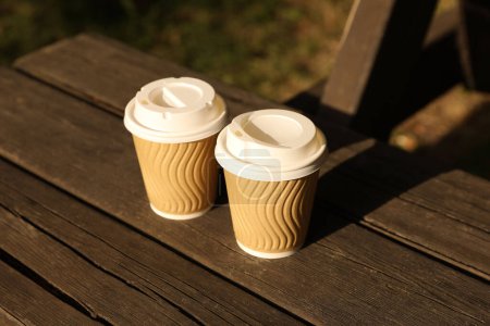 Photo for Paper cups on wooden table outdoors. Coffee to go - Royalty Free Image