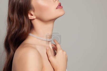 Téléchargez les photos : Jeune femme portant élégant collier de perles sur fond gris, gros plan. Espace pour le texte - en image libre de droit
