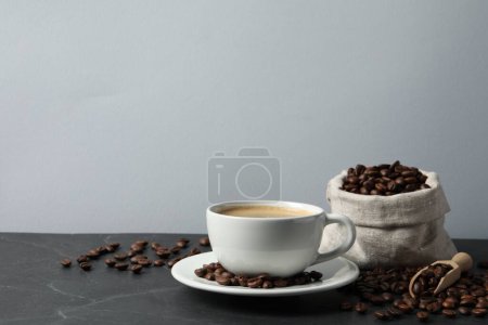 Téléchargez les photos : Tasse de café aromatique et haricots sur table grise. Espace pour le texte - en image libre de droit
