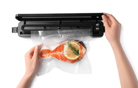Woman using vacuum sealer on white background, top view. Salmon with lemon in pack