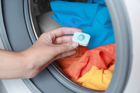 Photo for Woman putting water softener tablet into washing machine, closeup - Royalty Free Image