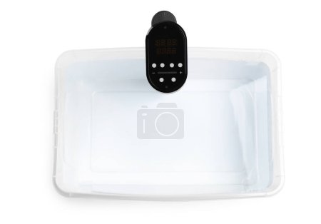 Téléchargez les photos : Cirateur d'immersion thermique dans un récipient en plastique avec de l'eau isolée sur blanc, vue de dessus. Cuisinière Sous vide - en image libre de droit