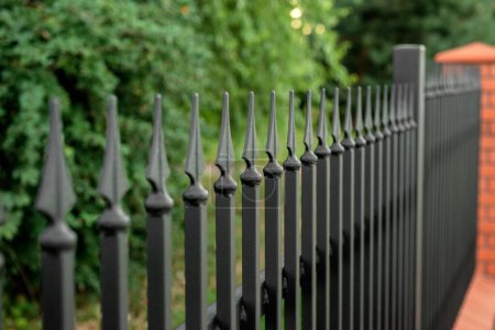 Beautiful brick fence with iron railing outdoors, closeup