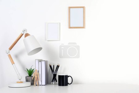 Foto de Cómodo lugar de trabajo con escritorio blanco cerca de la pared en casa - Imagen libre de derechos