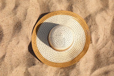 Photo for Beautiful beige straw hat on sand, top view - Royalty Free Image