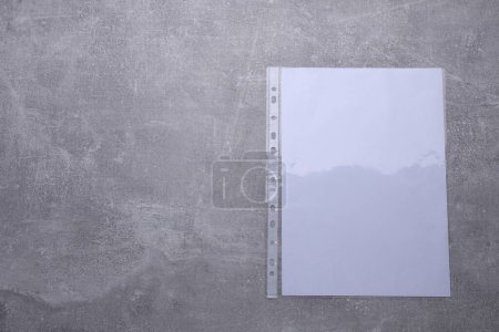 Foto de Bolsillo perforado con hoja de papel sobre mesa gris claro, vista superior. Espacio para texto - Imagen libre de derechos