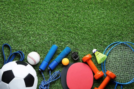 Téléchargez les photos : Ensemble de différents équipements sportifs colorés sur herbe verte, à plat. Espace pour le texte - en image libre de droit