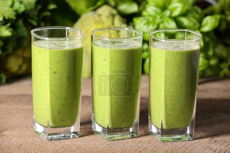 Photo for Glasses of fresh green smoothie and ingredients on wooden table - Royalty Free Image