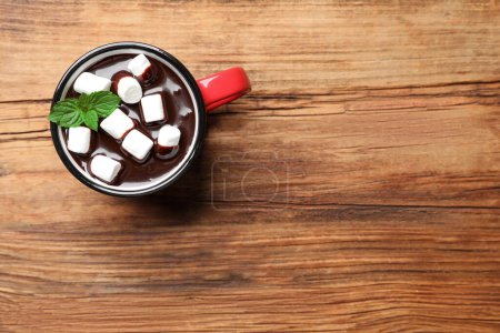 Photo for Mug of delicious hot chocolate with marshmallows and fresh mint on wooden table, top view. Space for text - Royalty Free Image