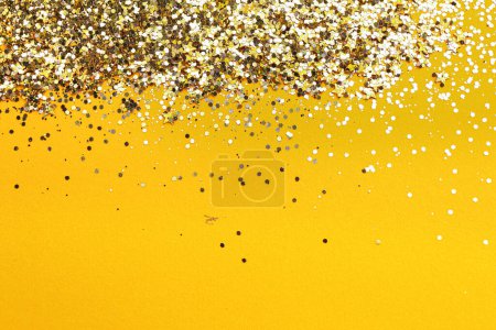 Photo for Shiny bright golden glitter on pale orange background. Space for text - Royalty Free Image