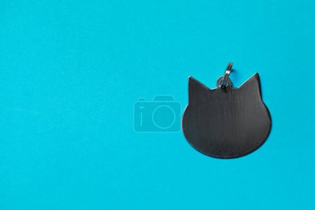 Photo for Silver pet tag in shape of cat with ring on light blue background, top view. Space for text - Royalty Free Image