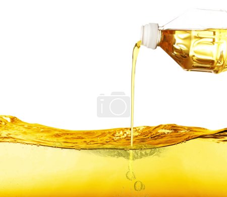 Téléchargez les photos : Verser l'huile de cuisson de la bouteille sur fond blanc - en image libre de droit
