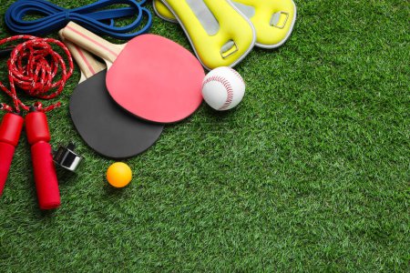 Photo for Set of different colorful sports equipment on green grass, above view. Space for text - Royalty Free Image