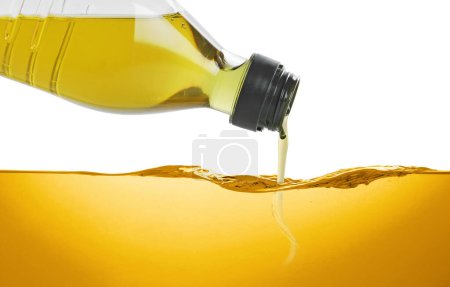 Téléchargez les photos : Verser l'huile de cuisson de la bouteille sur fond blanc - en image libre de droit