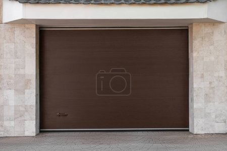 Photo for Brown modern counterweight garage doors on building - Royalty Free Image