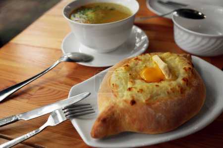 Téléchargez les photos : Délicieux Adjarian khachapuri frais avec fromage et oeuf sur table en bois - en image libre de droit