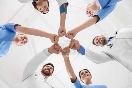 Photo for Team of medical doctors putting hands together indoors, bottom view - Royalty Free Image