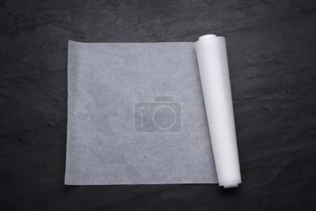 Téléchargez les photos : Rouleau de papier cuisson sur table noire, vue de dessus - en image libre de droit
