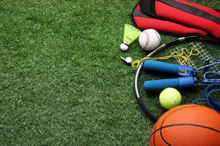 Photo for Set of different colorful sports equipment on green grass, above view. Space for text - Royalty Free Image