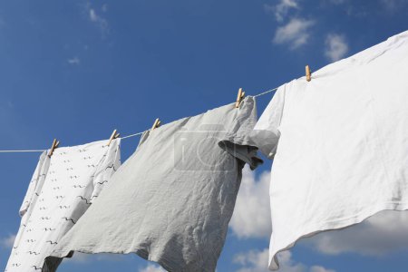 Wäscheleine mit sauberer Kleidung gegen den Himmel. Wäsche draußen trocknen