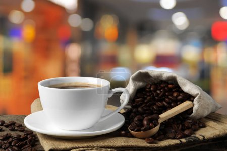 Téléchargez les photos : Tasse de café aromatique et haricots sur table en bois à l'intérieur - en image libre de droit