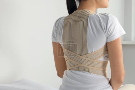 Photo for Closeup of woman with orthopedic corset indoors, back view. Space for text - Royalty Free Image