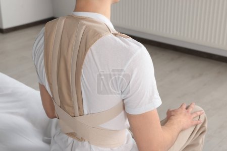 Photo for Closeup view of man with orthopedic corset sitting in room - Royalty Free Image
