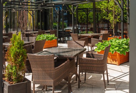 Foto de Hermosa cafetería con muebles elegantes y plantas al aire libre - Imagen libre de derechos