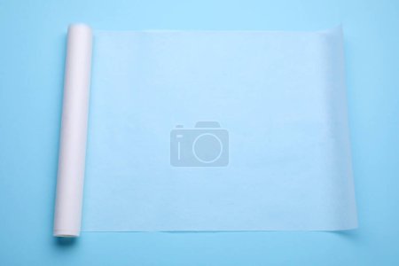 Téléchargez les photos : Rouleau de papier cuisson sur fond bleu clair, vue de dessus - en image libre de droit
