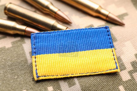 Photo for Military patch and bullets on pixel Ukrainian camouflage, closeup - Royalty Free Image