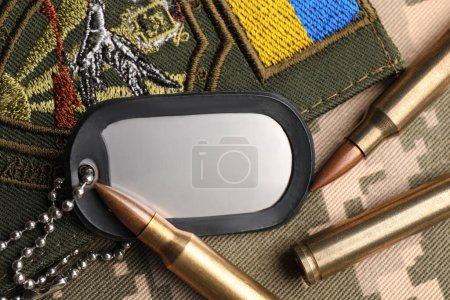 Téléchargez les photos : Balles, plaque d'identité militaire et patch ukrainien sur camouflage pixel, pose à plat - en image libre de droit