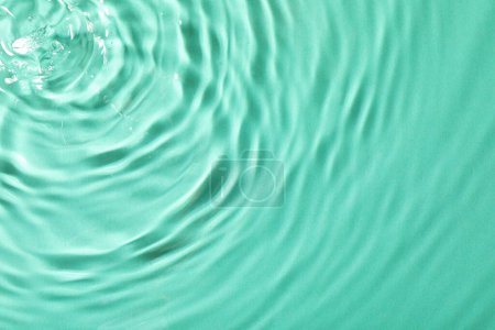 Téléchargez les photos : Vue rapprochée de l'eau avec surface ondulée sur fond bleu clair - en image libre de droit