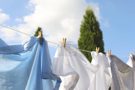 Saubere Kleidung, die draußen an der Wäscheleine hängt, Nahaufnahme. Wäsche trocknen
