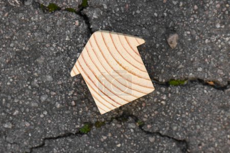 Photo for Wooden house model on cracked asphalt, top view. Earthquake disaster - Royalty Free Image