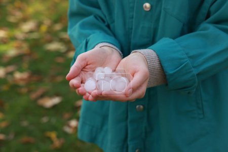 Photo for Woman holding hail grains after thunderstorm outdoors, closeup - Royalty Free Image