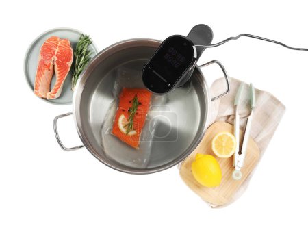 Photo for Thermal immersion circulator and vacuum packed salmon in pot on white background, top view. Sous vide cooking - Royalty Free Image