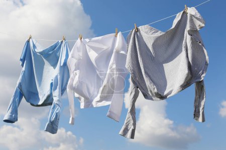 Saubere Kleidung hängt an der Wäscheleine gegen den Himmel. Wäsche trocknen