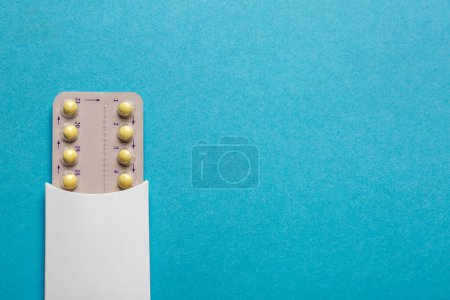 Téléchargez les photos : Pilules contraceptives sur fond bleu clair, vue du dessus. Espace pour le texte - en image libre de droit