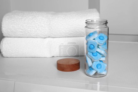 Photo for Glass jar with water softener tablets on washing machine in bathroom, space for text - Royalty Free Image