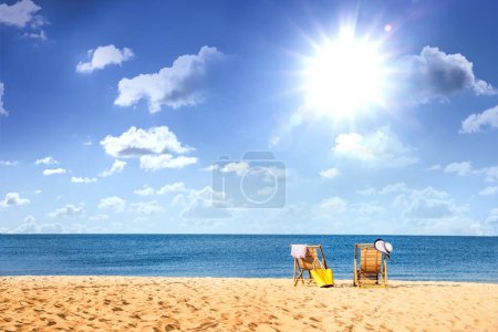 Foto de Tumbonas de madera vacías en la playa de arena cerca del mar en un día soleado - Imagen libre de derechos