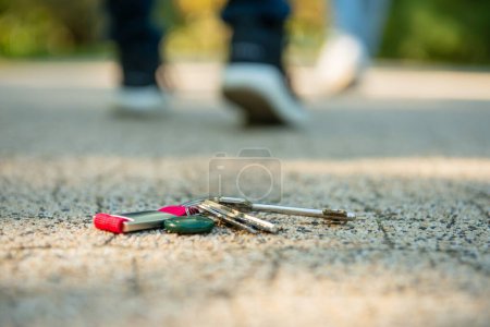 Téléchargez les photos : Les hommes marchent dehors, se concentrent sur les clés perdues - en image libre de droit