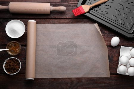 Téléchargez les photos : Rouleau de papier sulfurisé et ingrédients sur table en bois, plat - en image libre de droit