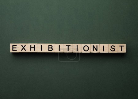 Téléchargez les photos : Word EXPOSITIONIST fait avec des cubes en bois sur fond vert foncé, pose plate - en image libre de droit