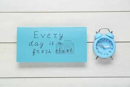 Téléchargez les photos : Phrase Every Day is A Fresh Start et réveil sur table en bois blanc, pose plate. Citation motivationnelle - en image libre de droit