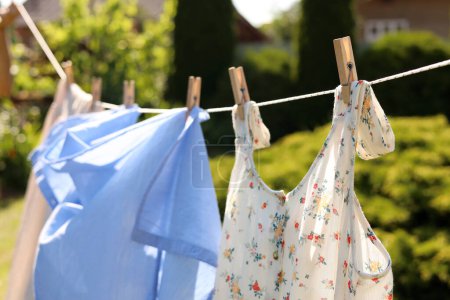 Saubere Kleidung hängt an der Wäscheleine im Garten. Wäsche trocknen
